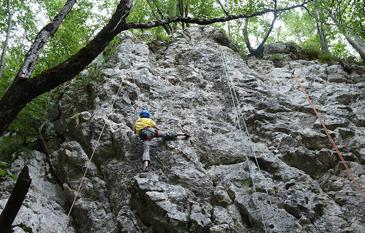 kid climbing on a natural rock