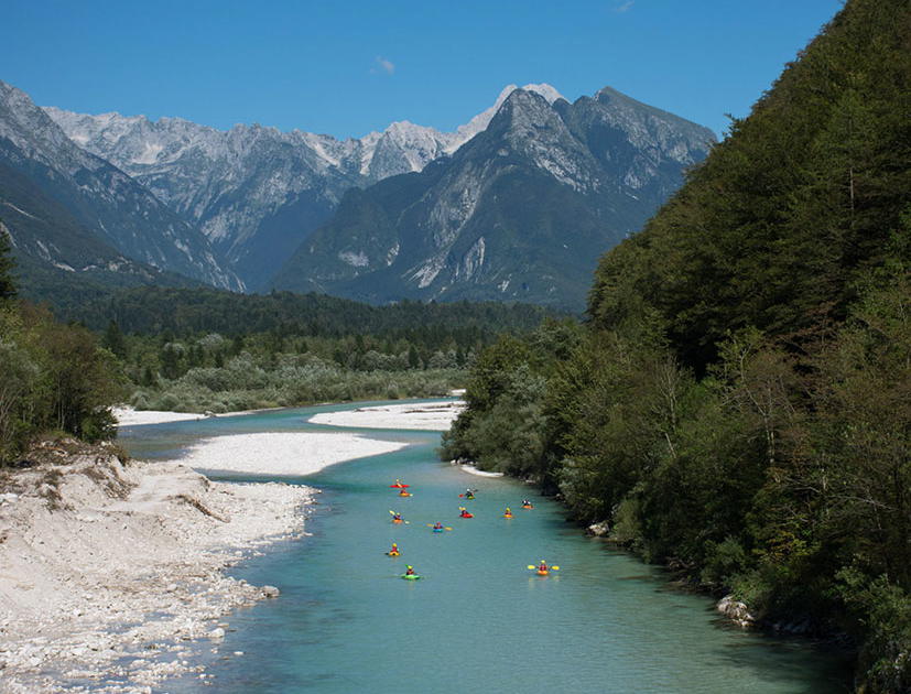 kayakers descending down the soča river on an easy section
